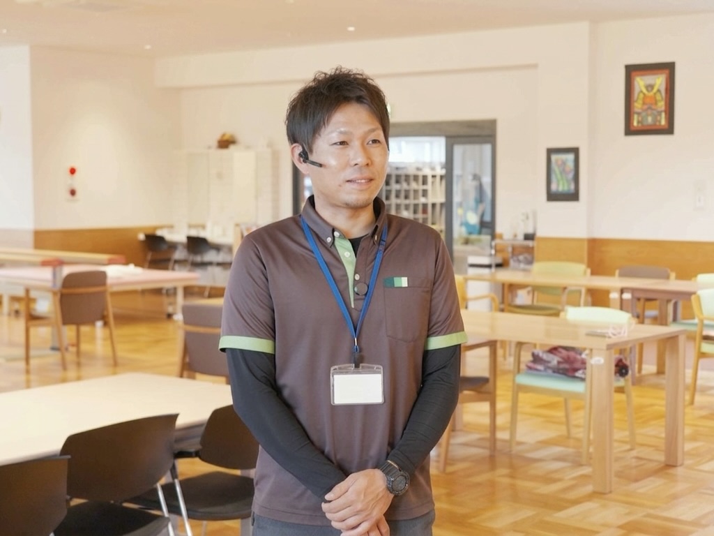 あさひホーム OpenComm2 PTTを着用しインタビューに応じる男性職員