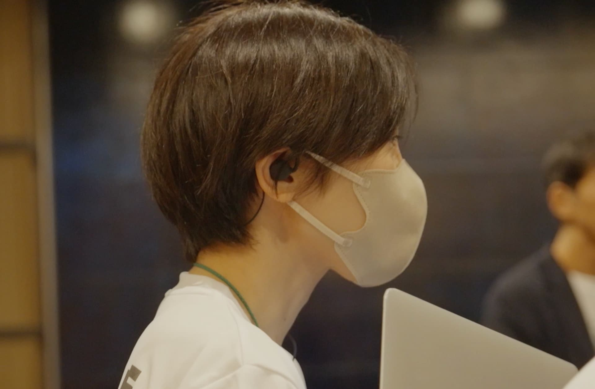 オープンイヤー型イヤフォンを装着して会話するセーフィー社員