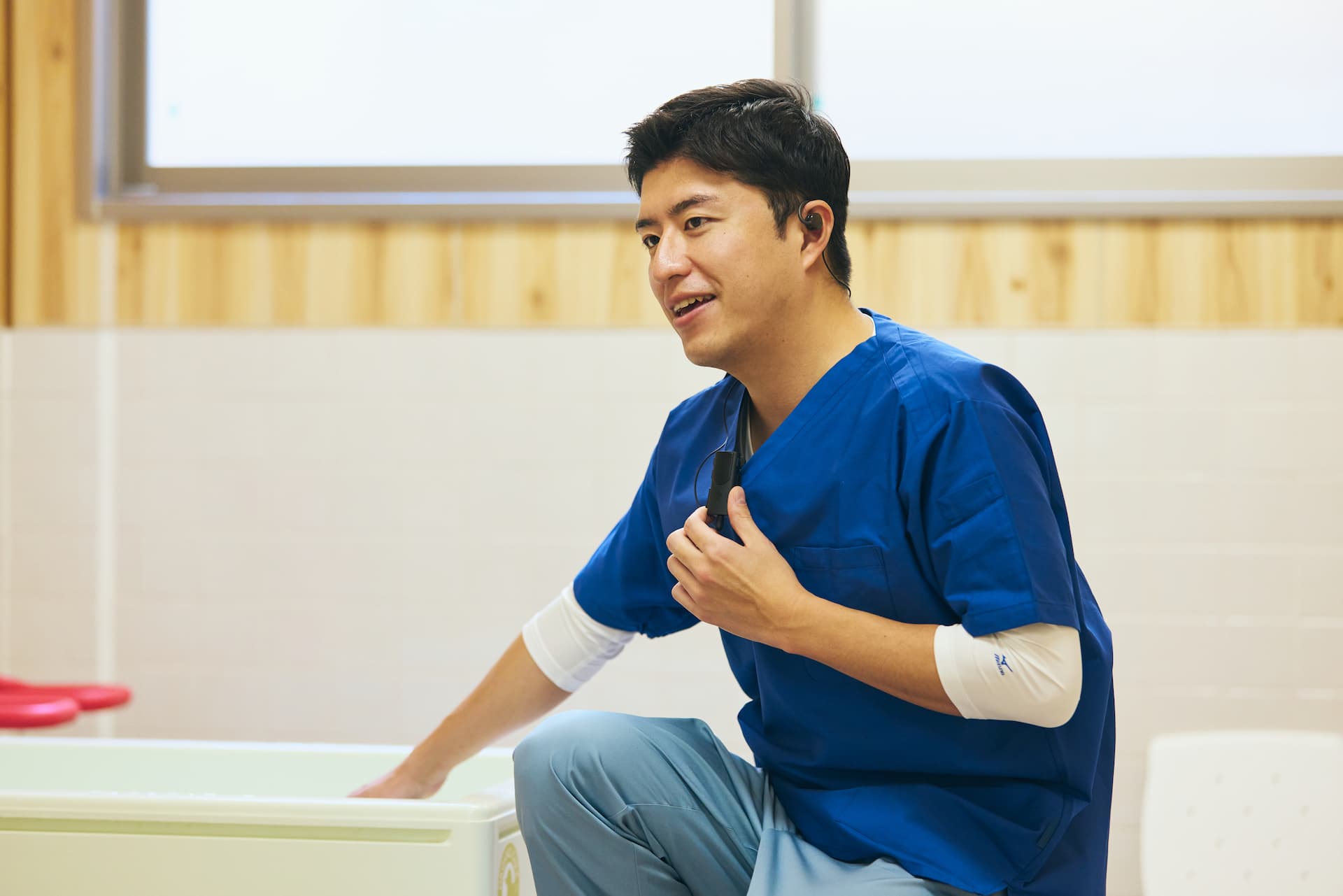 入浴準備中にインカムで会話する男性の介護職員イメージ