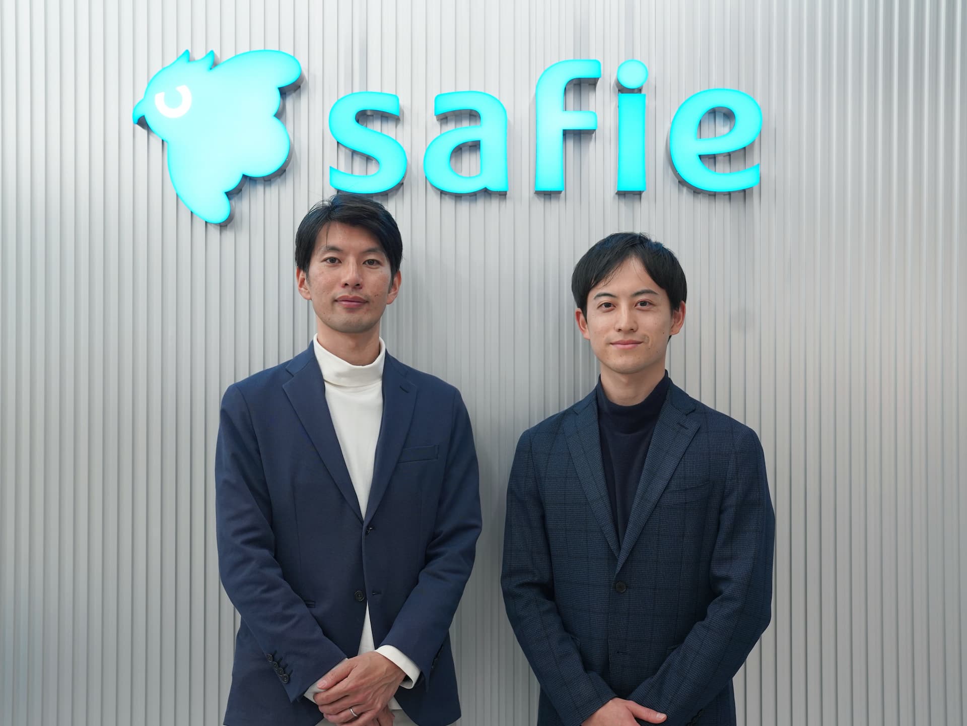Safie企業ロゴを背景にBONX社員とSafie社員のツーショット